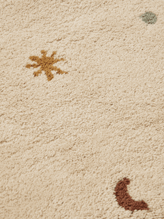 Close-up of the Skye rug pile showing ochre sun and rust moon motifs