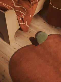Skye blanket in Sienna/Parchment over the side of a child's bed