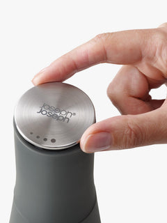 Brushed stainless-steel cap of the Milltop mill being twisted to adjust the grind
