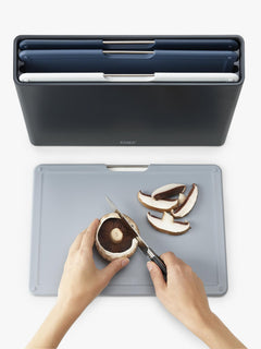 Chopping mushrooms on a grey Folio board with the storage case behind
