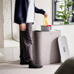Lifting a tote bag out of the Tota Trio basket by its handles
