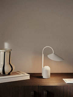 Arum Portable Lamp in Cashmere on a dark wood sideboard