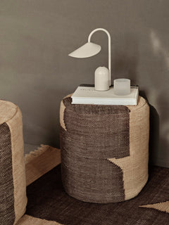 Cashmere Arum Portable Lamp on a tray atop a woven pouffe