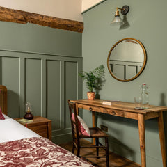 Ribbed glass funnel wall light fitted beside a bed
