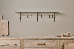 Basti antique brass shelf mounted above a wooden sideboard
