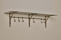 Angled view of the Basti antique brass shelf showing the slatted top and hooks