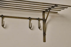 Close-up of the hand-hammered antique brass hooks and bracket on the Basti shelf