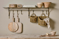 Basti shelf wall hung in a kitchen, holding boards, baskets and bowls