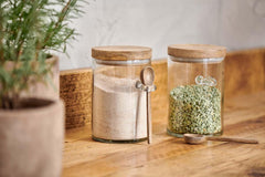 Kossi glass storage jars filled with flour and dried peas on a wooden worktop
