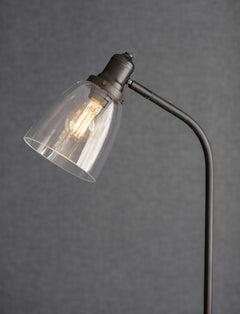 Close-up of the glass dome shade and antique bronze fitting of the Hoxton Dome floor lamp