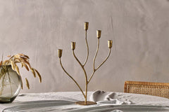 Palani candelabra with unlit candles beside a glass vase