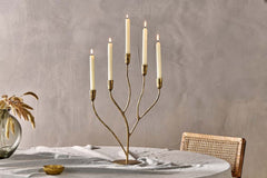 Palani candelabra holding five lit dinner candles on a dining table