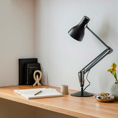 Anglepoise Type 75 desk lamp in jet black on an oak desk beside books and a notepad