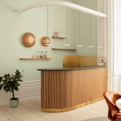 A row of pearl white Asteria Micro pendants hung over a curved counter