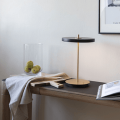 Black Asteria Move lamp standing on a wooden console table