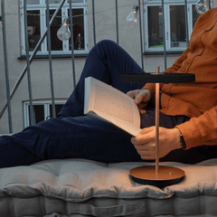 Black Asteria Move lamp lighting an open book at dusk