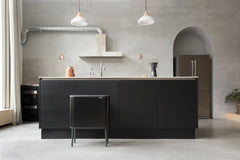 Bo Touch Bin in matt black tucked against a dark kitchen island in a bright room