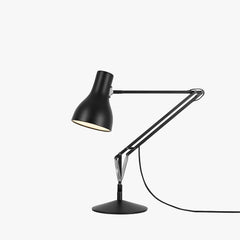 Anglepoise Type 75 desk lamp in jet black lit against a white background